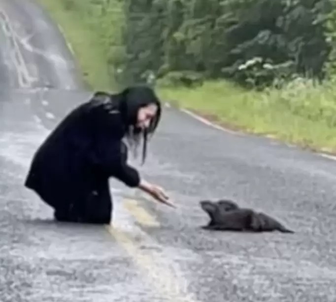 Mujer y nutria en la calle